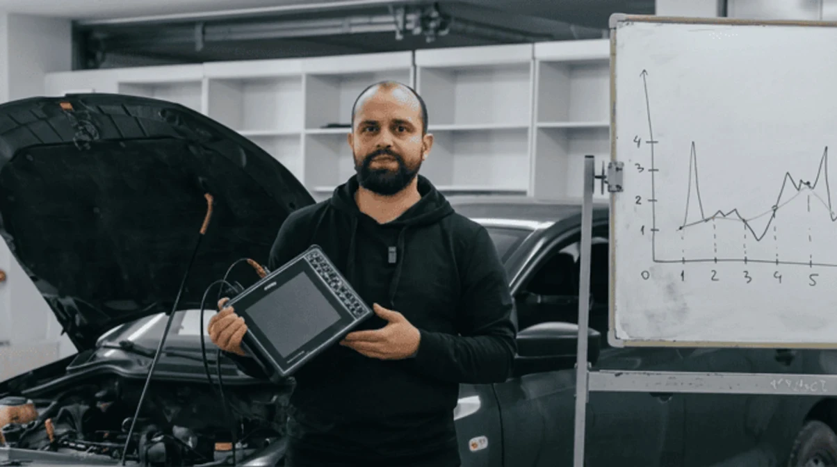 Виталий Кострицкий с планшетом у автомобиля